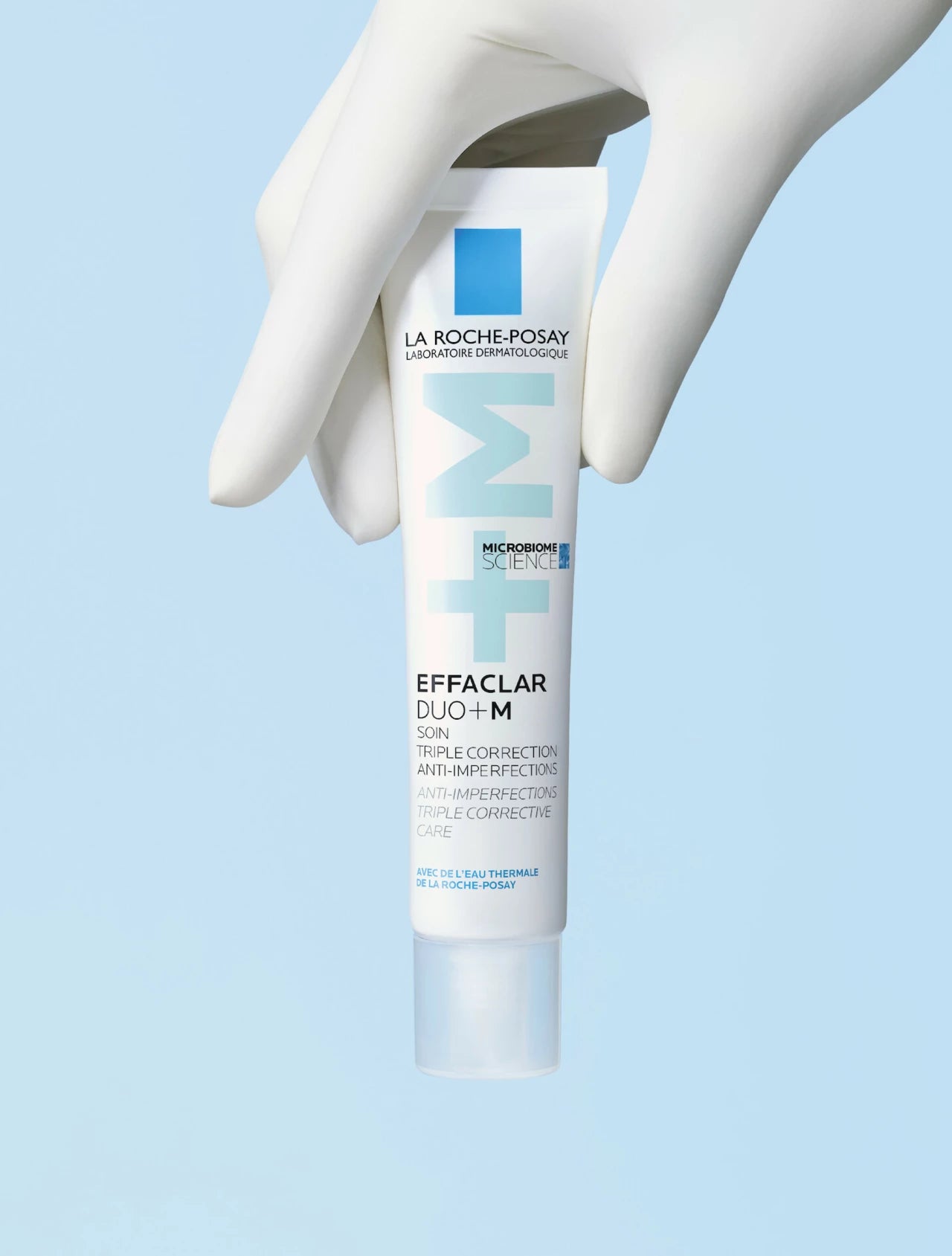La Roche-Posay - Effaclar Duo+M pÄ en blÄ bakgrund, hÄlls av en person.
