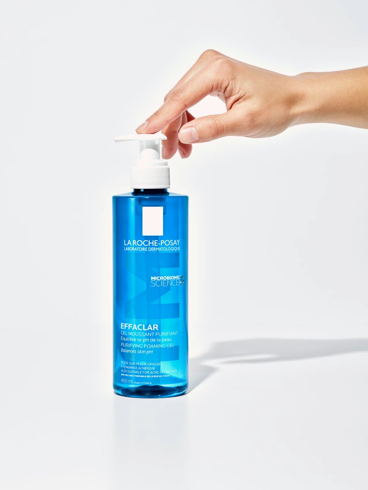 La Roche-Posay - Effaclar Purifying Foaming Gel på en vit bakgrund, pumpas av en person.