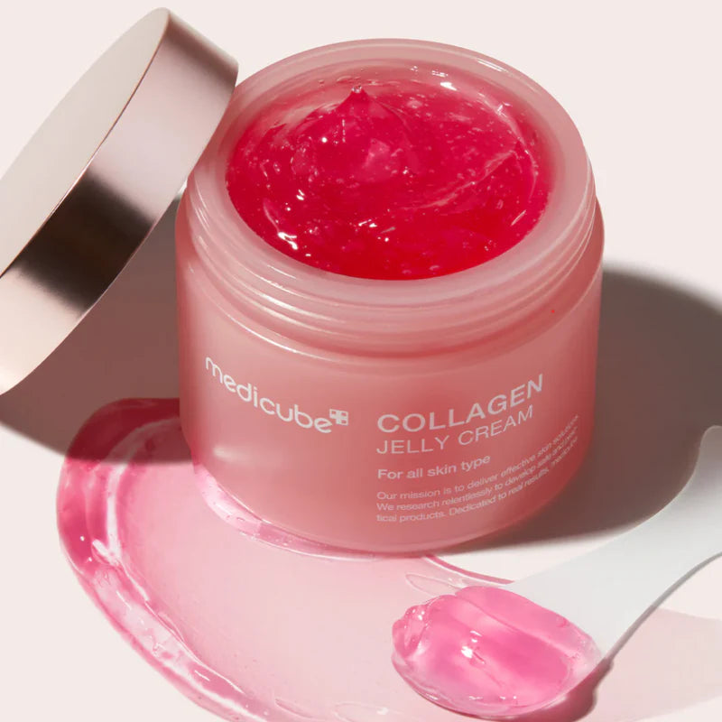 Medicube Collagen Jelly Cream på en vit bakgrund där produkten lock är av och produktens innehåll är mörk rosa färgad geleformad kräm för djup återfuktning, fastare hud och reducering av fina linjer och rynkor.