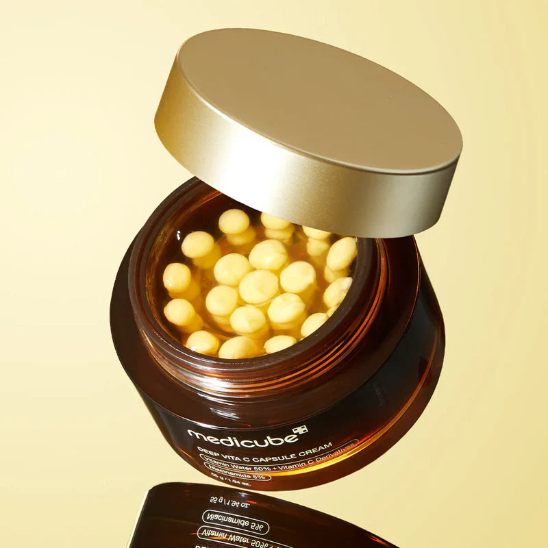 Medicube Deep Vita C Capsule Creampå beige / gul bakgrund med en öppen lock där man kan se produktens innehåll 